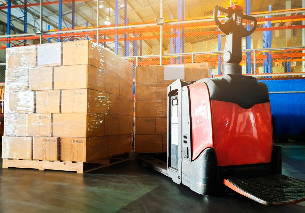 A red forklift in front of palettes within a warehouse to illustrate shipping costs.